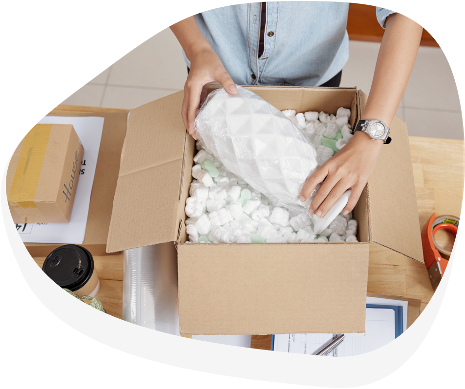 Person packt Produkt in Karton - ein Service, der Teil von Fulfillmentkosten ist